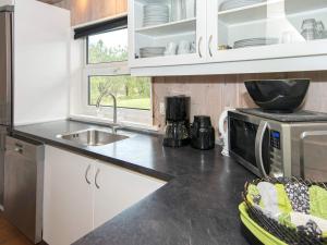 cocina con fregadero y microondas en 12 person holiday home in Bl vand, en Ho