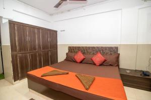a bedroom with a large bed with red pillows at Travo Suites Panjim in Panaji