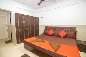 a bedroom with a large bed with red pillows at Travo Suites Panjim in Panaji