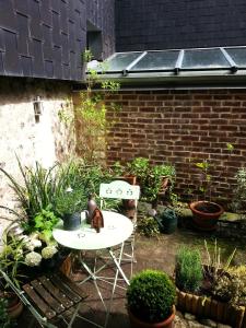 una mesa y sillas en un jardín con plantas en -Coeur historique -My Little Garden - Parking gratuit 500m -La Clef de Honfleur, en Honfleur