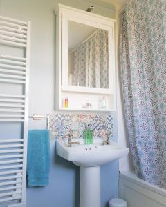 a bathroom with a sink and a mirror at Ula Cottage in Saint Helens