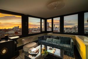 una sala de estar con sofá y un grupo de ventanas en CoolRooms Palacio de Atocha en Madrid