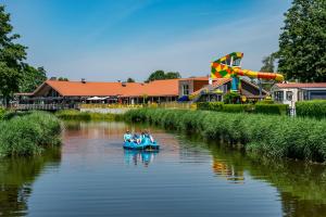 Un grupo de personas están en un barco en un río. en Camping de Vogel en Hengstdijk