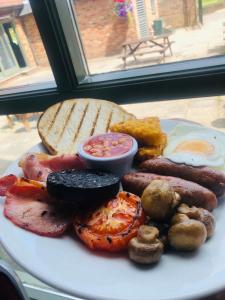 a plate of breakfast food with sausage and bread at The Players Golf Club in Bristol