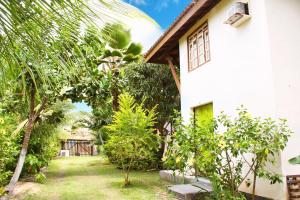 a garden in front of a white house at Condominio Sao Cristovao in Santa Cruz Cabrália