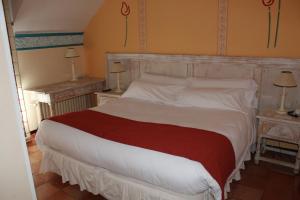 a bedroom with a large white bed and two end tables at Hotel La Posada De Alameda in Alameda del Valle