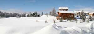 einen schneebedeckten Hof mit einem Haus im Hintergrund in der Unterkunft Vacancéole - Résidence Les Gorges Rouges in Guillaumes