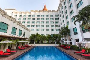 a hotel with a swimming pool in front of a building at Mida Grande Hotel Dhavaravati Nakhon Pathom - SHA PLUS in Nakhon Pathom