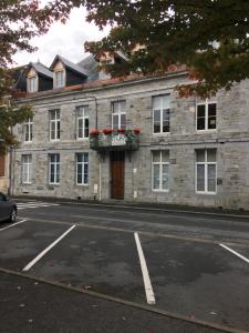 a brick building with a door and flowers on it at Appartement style industriel avec terrasse in Givet
