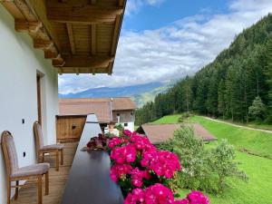 a table with pink flowers on a balcony with a view at Astegger Talhof in Finkenberg