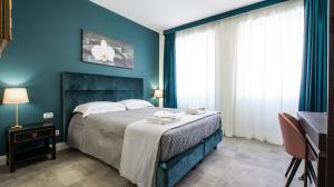 1 dormitorio con 1 cama con pared azul en Regolo Rooms Vaticano, en Roma