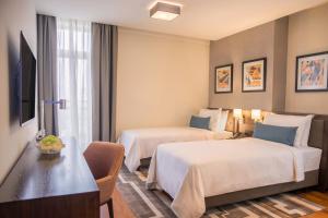 una camera d'albergo con due letti e un tavolo di Bosmal Arjaan by Rotana a Sarajevo