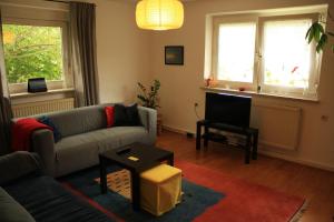 ein Wohnzimmer mit einem Sofa und einem TV in der Unterkunft Ferienwohnung kleines Lautertal in Herrlingen