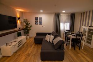 ein Wohnzimmer mit einem Sofa und einem Tisch in der Unterkunft Apartamentos Adarve Toledo in Toledo
