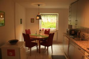 eine Küche mit einem Tisch und Stühlen sowie einem Fenster in der Unterkunft Ferienwohnung kleines Lautertal in Herrlingen