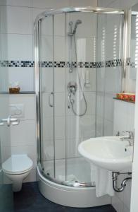 ein Bad mit einer Dusche und einem Waschbecken in der Unterkunft Hotel Garni Ammergauer Hof in Oberammergau