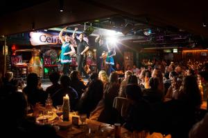 a crowd of people in a bar with performers on a stage at Arlington Hotel O'Connell Bridge in Dublin