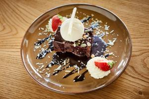 a plate with a piece of chocolate cake with whipped cream and strawberries at Arlington Hotel O'Connell Bridge in Dublin