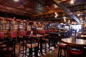a restaurant with tables and chairs and a bar at Arlington Hotel O'Connell Bridge in Dublin