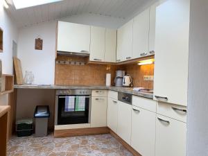 a kitchen with white cabinets and an oven at Haus Latschenheim in Ramsau am Dachstein