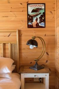 a lamp on a table next to a bed at Tolcarne Beach Cabins in Newquay