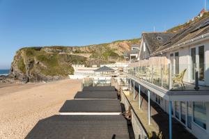 ニューキーにあるTolcarne Beach Cabinsの建物のバルコニーからビーチの景色を望めます。