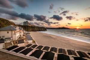 a view of a beach with a house and the ocean at Tolcarne Beach Cabins in Newquay