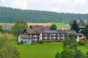 a large building in the middle of a green field at Hotel garni Siebenstern in Bischofsgrün