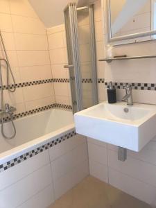 a white bathroom with a sink and a bath tub at Cityhotel Ahlen Garni in Ahlen +45 photos