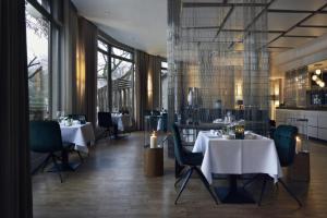 ein Restaurant mit weißen Tischen und Stühlen und Fenstern in der Unterkunft M Hotel in Genk