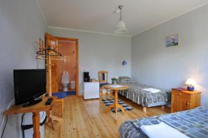ein Zimmer mit einem Schlafzimmer mit zwei Betten und einem Flachbildfernseher in der Unterkunft Villa Ene in Pärnu