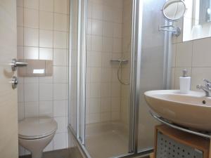 a bathroom with a shower and a sink and a toilet at Gästehaus Grath in Lindenberg im Allgäu