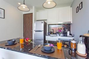 a kitchen with two plates of food on a counter at Palmyrah Surin Apartments by Beringela in Surin Beach
