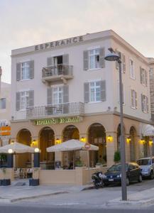 un gran edificio blanco con sombrillas delante en Esperance 1, en Ermoupoli