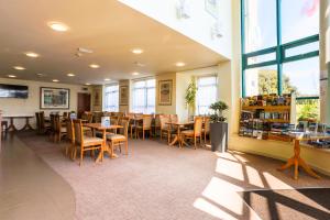 a restaurant with tables and chairs and windows at Sefton Express Hotel in Ballasalla