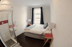 a bedroom with a bed and a bathroom with a mirror at 91 Loop Boutique Hostel in Cape Town