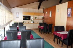 a dining room with tables and chairs and a television at Hotel TISA in Busovača