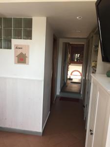 een hal in een huis met een gang die naar een deur leidt bij APPARTAMENTINO ROMANTICO in Rio nell Elba