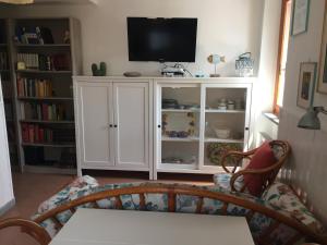 uma sala de estar com uma televisão e um armário branco em APPARTAMENTINO ROMANTICO em Rio nellʼElba