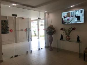 - un hall avec un vase de fleurs et un miroir dans l'établissement Lorenzo Hôtel Abidjan, à Abidjan