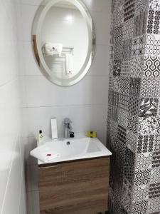 y baño con lavabo blanco y espejo. en Lorenzo Hôtel Abidjan, en Abiyán