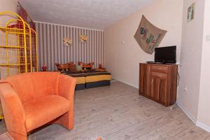 ein Schlafzimmer mit einem Bett, einem Stuhl und einem TV in der Unterkunft Preisgünstiger Bungalow für 3 Personen auf Rügen in Sagard
