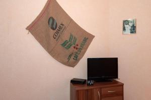 Eine Flagge hängt an einer Wand neben einem Fernseher in der Unterkunft Preisgünstiger Bungalow für 3 Personen auf Rügen in Sagard