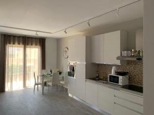 a kitchen with white cabinets and a table with chairs at St Julians Apartment 2 in St. Julianʼs