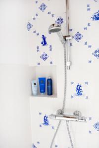 a shower in a bathroom with blue and white tiles at Jackie O Studio in Amsterdam