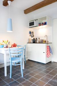 a kitchen with a white table and a blue chair at Jackie O Studio in Amsterdam
