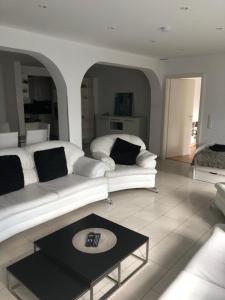 ein Wohnzimmer mit einem weißen Sofa und einem Bett in der Unterkunft Ferienwohnung Amperblick Fürstenfeldbruck in Fürstenfeldbruck