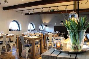 a restaurant with wooden tables and chairs and windows at Tiny floating house, Mallorca in Maastricht