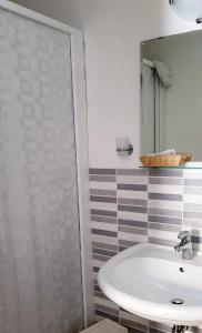 a bathroom with a white sink and a mirror at Dépendance Lisa in Pineto