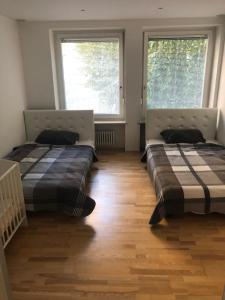 zwei Betten in einem Zimmer mit zwei Fenstern in der Unterkunft Ferienwohnung Amperblick Fürstenfeldbruck in Fürstenfeldbruck